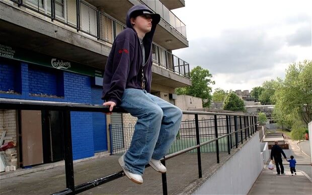Underprivledged Boy sitting on railing